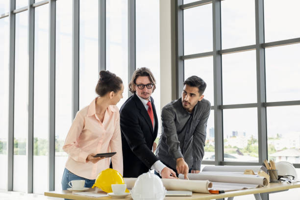 istock Engineer team meeting to inspect the construction blueprint drawings, work plan and distribute work before starting the building 1700078615