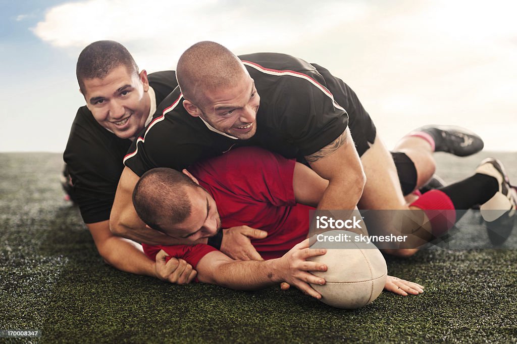 Rugby players in action. Three rugby players during scrum action.    Rugby - Sport Stock Photo