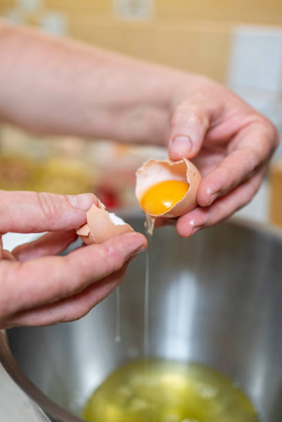 istock A woman breaks eggs in a bowl in the kitchen. cooking. 1700087931
