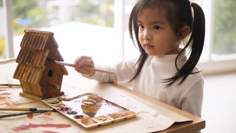 Little Girl Painting At The Model House