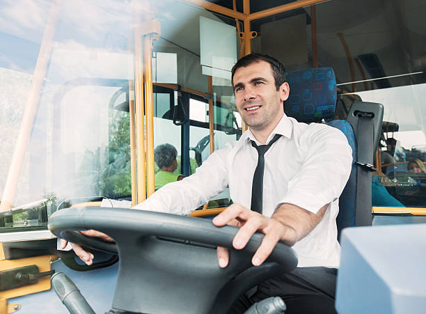Bus driver. Cheerful bus driver driving a bus. He is seen through the windscreen. coach bus photos stock pictures, royalty-free photos & images