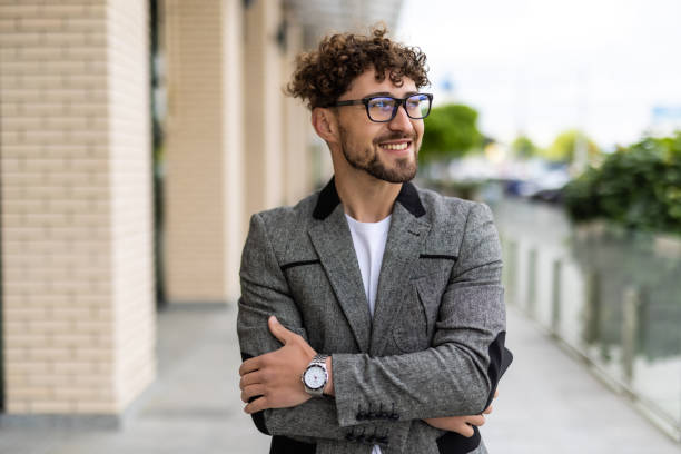istock Successful confident caucasian bearded businessman in suit standing outdoors on background office building 1700104121