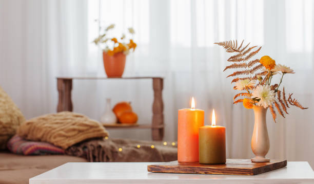 istock burning candles with autumn decor on white table at home 1700104163