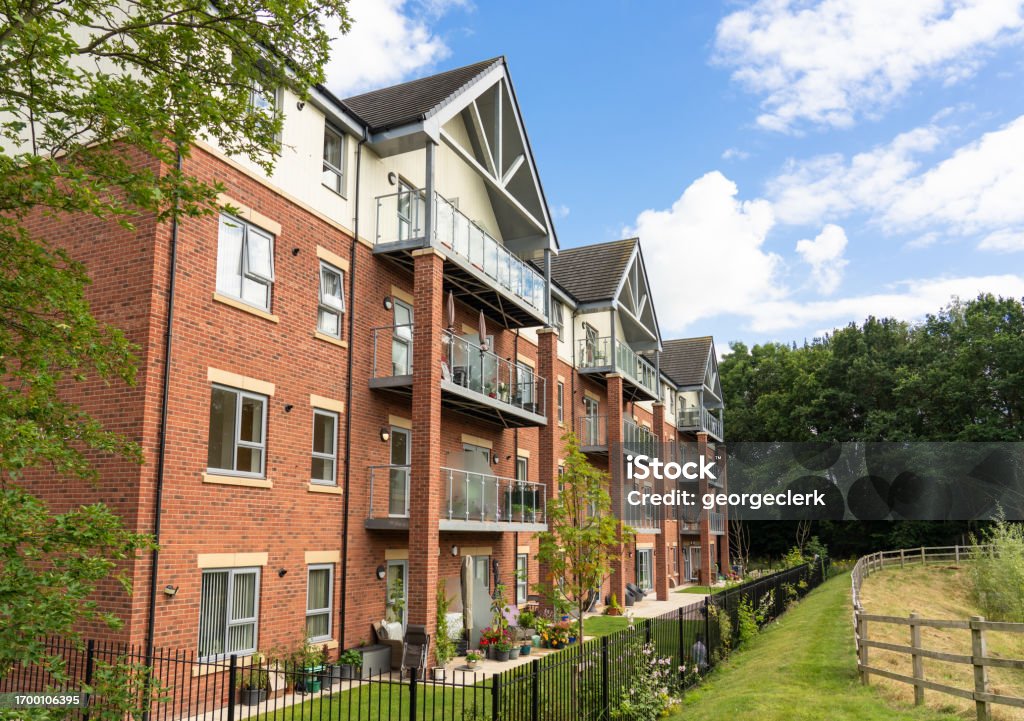 Suburban English apartment building A modern, brick built apartment building on the rural outskirts of a town in southeast England. Apartment Stock Photo