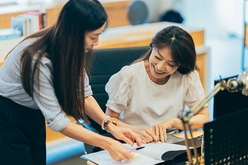 A young female employee is engaged in a conversation with her supervisor, seeking clarification and guidance on work-related matters. Their discussion reflects a proactive approach to problem-solving and a positive working relationship within the organization.
