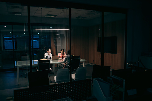 After regular working hours, three employees chose to stay at the company for overtime work. The lights in the office had already been turned off, with only the lights in the conference room still on.