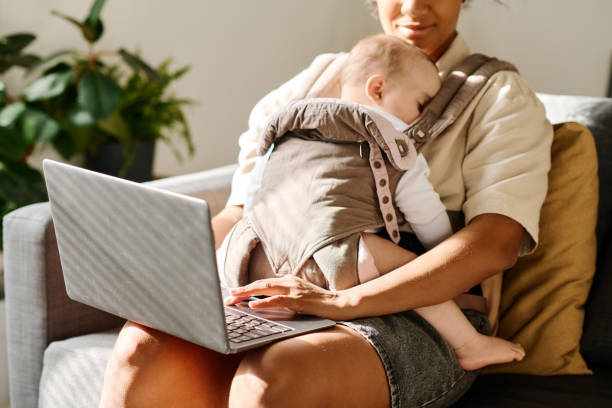 istock Woman with baby working online on laptop 1700117762