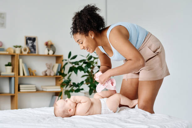 istock Young mom dressing her baby in the room 1700118821