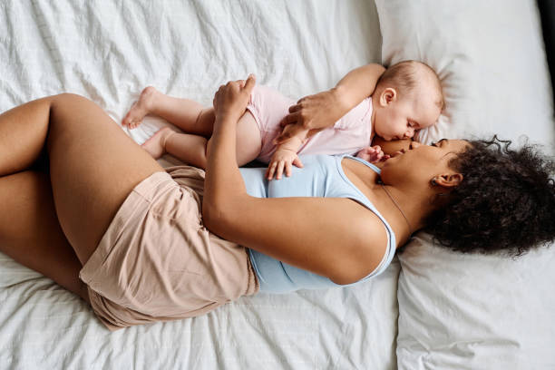 istock Mother sleeping with her baby on bed 1700119402