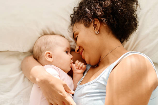 istock Mother lying with her baby on bed 1700120171