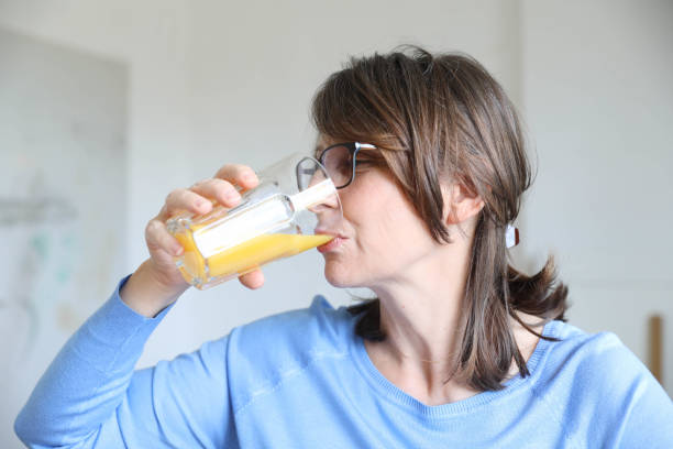 istock Elderly woman drinking fresh juice in the kitchen 1700127107