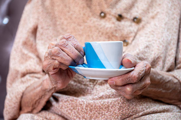 istock Old woman drinking coffee with smile on her face 1700128244