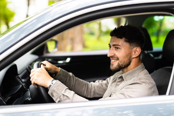 istock Young Man driving his car on way to work. 1700143370
