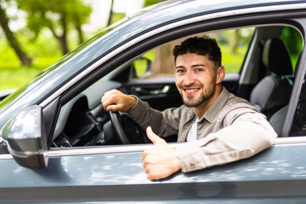 istock Young man smiling happy doing ok sign driving car. 1700145670