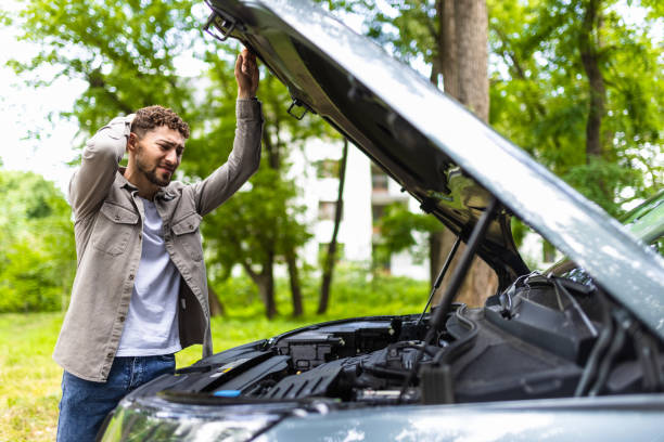 istock Man checking his broke down car on the street 1700146224