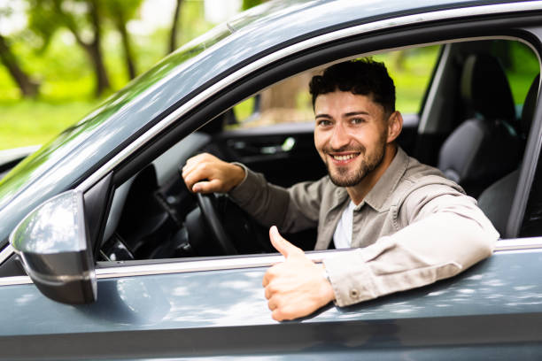 istock Young man smiling happy doing ok sign driving car. 1700148989