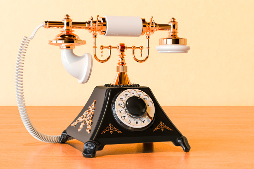 Black old-fashioned phone on the wooden table, 3D rendering