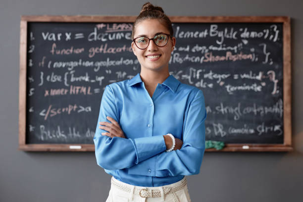 istock Young teacher standing in classroom 1700166610