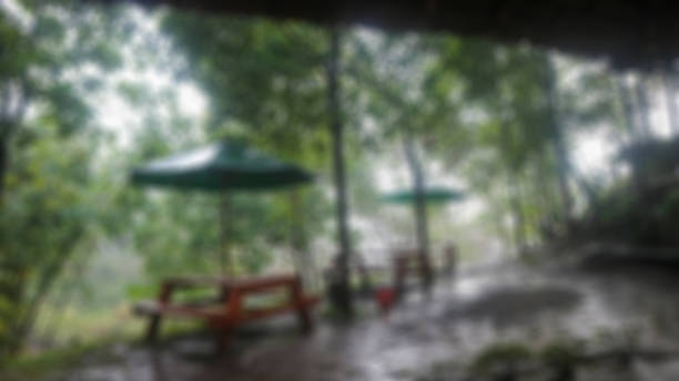 istock Wooden table with umbrella on a rainy day 1700178701