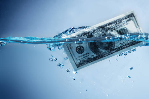 istock Money laundering. US Dollar banknotes in the water. Copy space. 1700209739