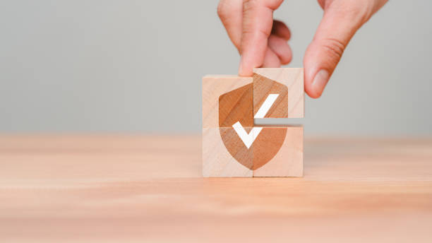 istock Hand put a wooden cube block with identity proof icon for security protection system on wood table. Quality assurance of business service. Certified guarantee approval or secure access system concept. 1700212425