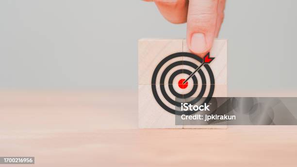 Hand Put A Goal Icon On Wooden Cube Block On Wood Table Business Concept Of Growth And Goals In Next Year Targets Objectives Business Success Planning Achievement Kpi And Okr Stock Photo - Download Image Now