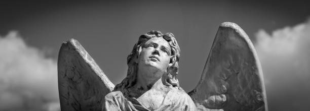 istock Angel. Fragment of ancient stone statue. Horizontal black and white image. 1700217492