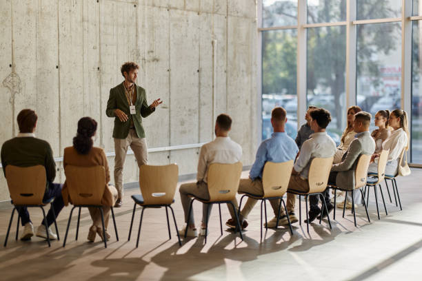 istock Young male leader talking on a group therapy in the office. 1700220230