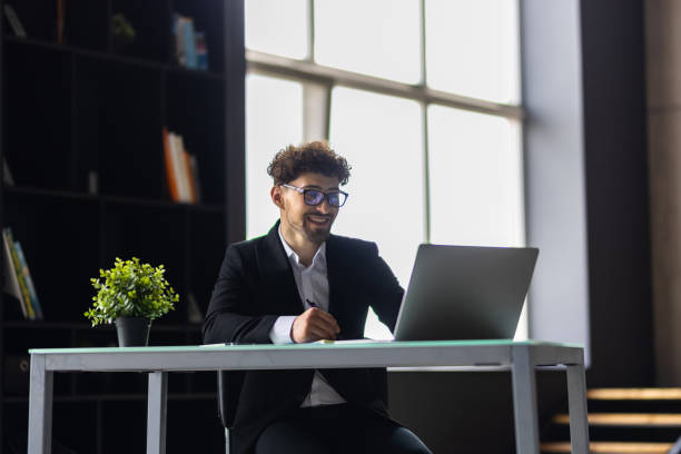 istock Businessman working in office. Young handsome man working on laptop. 1700226352