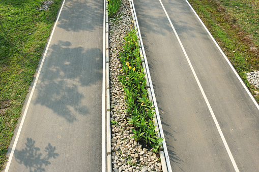 Empty asphalt road with garden on traffic island aerial top view.
