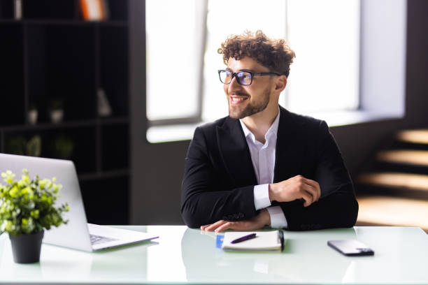 istock Creative business man working on a laptop in an open plan office. 1700237956