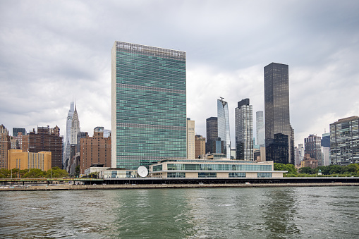 East River, Manhattan, New York, USA - August 12th 2023:  The United Nations Building seen from a boat on the East River