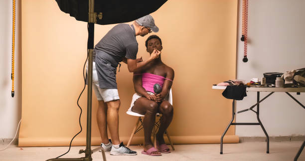 istock Visagiste applying lipstick while doing makeup on transgender preparing for photo shoot 1700239984