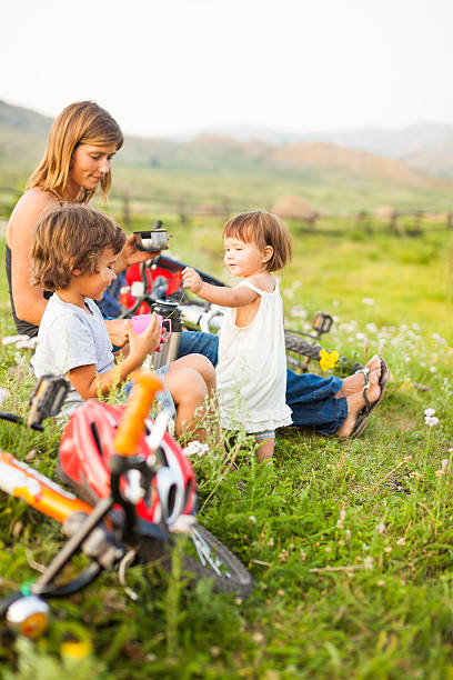 Happy one child family riding the bicycles in beautiful nature.   