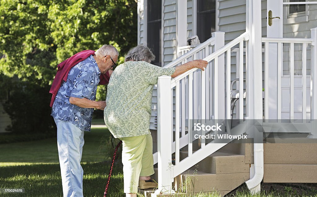 Uomo aiutando Senior moglie salire le scale - Foto stock royalty-free di Processo d'invecchiamento