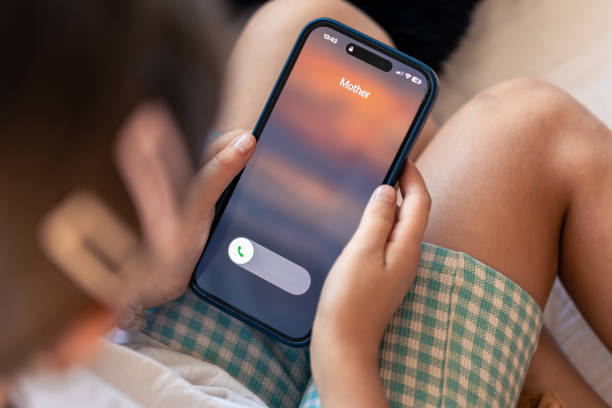 istock Smartphone in child hands with Incoming mother call on a screen. 1700247588
