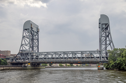 East River, Manhattan, New York, USA - August 12th 2023:  Railroad bridge over East River at the north end of Manhattan, where the river also is named Harlem River