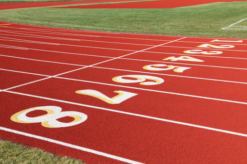 A synthetic red running track with numbered lanes 1 through 8 for competitive races.