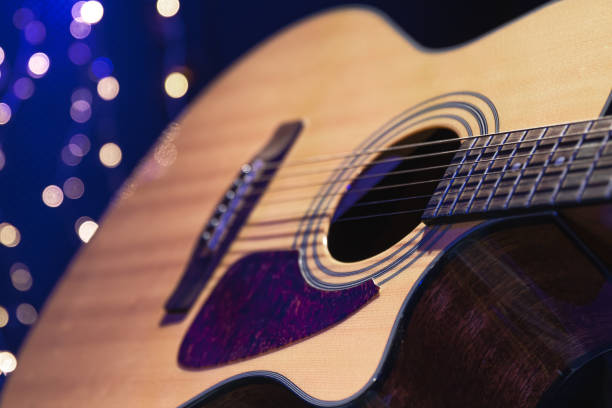 istock Close-up, acoustic guitar on a dark background with bokeh lights. 1700281679
