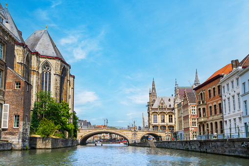 Ghent, Belgium - June 30, 2023: General view of the historic and touristic Belgian city of Ghent from the river Leie against medieval buildings in summer.