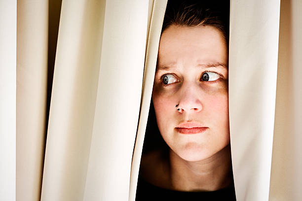 istock Nervous brunette beauty peeps sideways through curtains 170029362