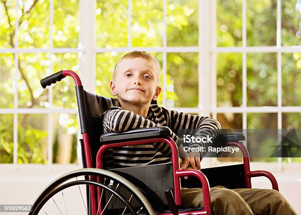 Little Boy Da Desafiante Vistazo Para Silla De Ruedas Foto de stock y más banco de imágenes de 8-9 años