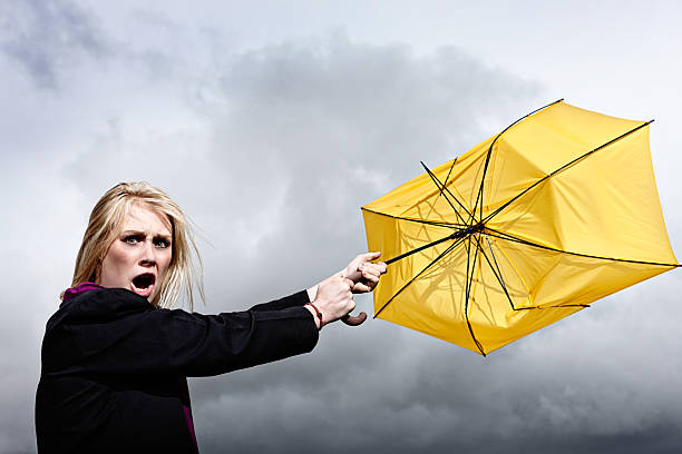istock Furious blonde is tugged through thunderstorm by ruined umbrella 170029656