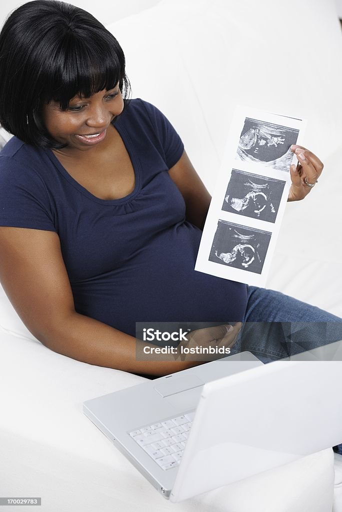 Felice afro-americana donna incinta condivisione scansioni tramite Internet - Foto stock royalty-free di Ecografia