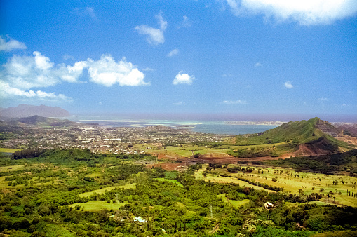 Vintage film photograph of the clouds and mist cover Oahu's rugged terrain, as seen from Nuʻuanu Pali lookout above Kaneohe, Hawaii.