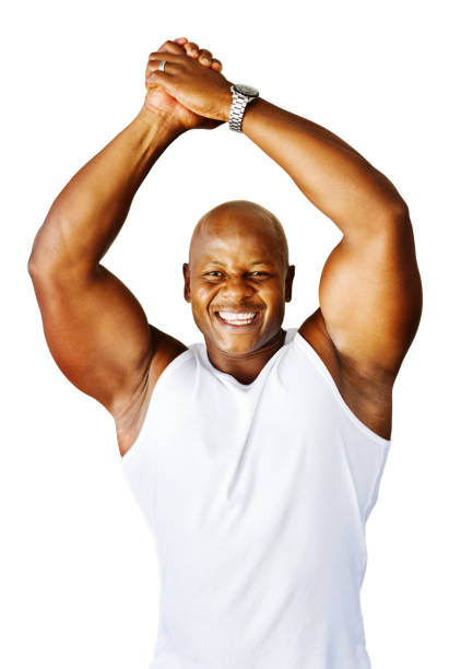 Portrait of muscular young man in sportswear standing with his hands on hips looking down against black background. Strong african athlete.