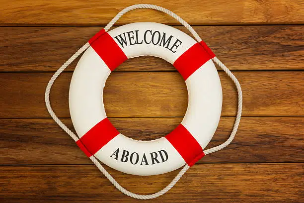 Traditional red and white life preserver on wooden background.