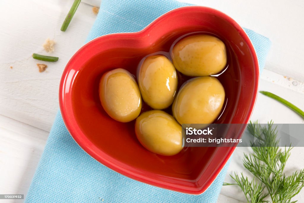 Aceitunas en una placa en forma de corazón - Foto de stock de Aceite de oliva libre de derechos