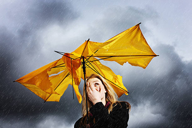 istock Pretty blonde with torn umbrella hides her face from storm 170032119