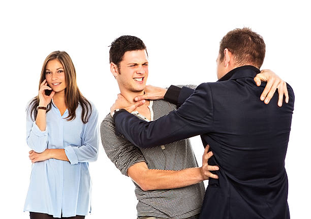 Two men fight for the favour of a pretty woman Two young men, perhaps rival suitors, fight each other furiously. A pretty young woman - possibly the cause of the argument - stands, smiling smugly, behind them. menage trois stock pictures, royalty-free photos & images